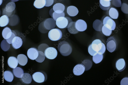 Blurred view of festive lights on dark background. Bokeh effect