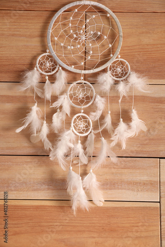 Beautiful dream catcher hanging on wooden wall