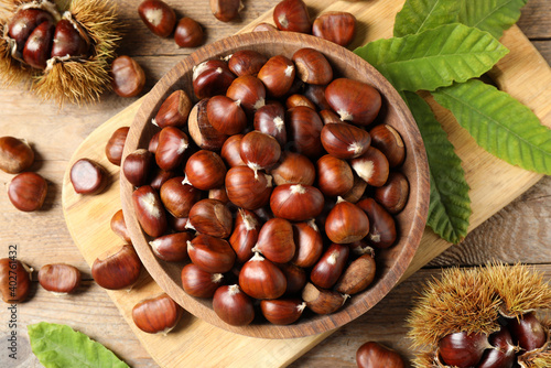 Fresh sweet edible chestnuts on wooden table  flat lay
