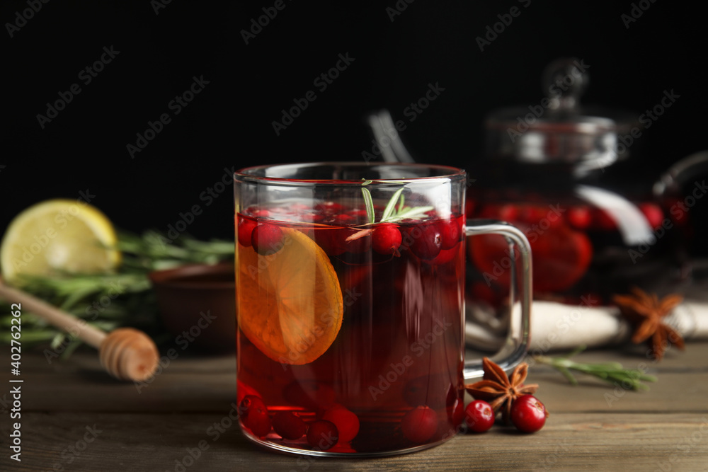 Fototapeta premium Tasty hot cranberry tea with rosemary and lemon on wooden table