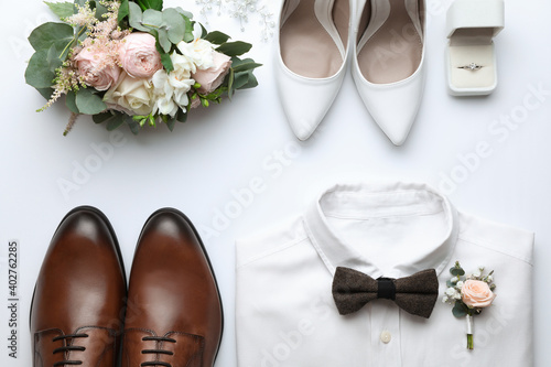 Composition with wedding shoes for bride and groom on white background, top view