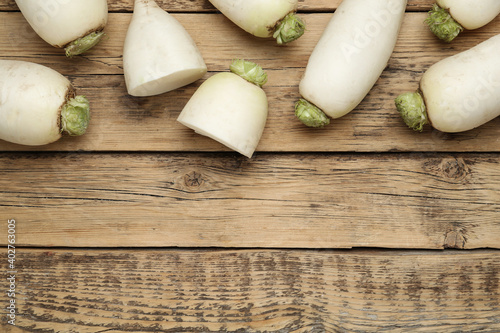 White turnips on wooden table, flat lay. Space for text