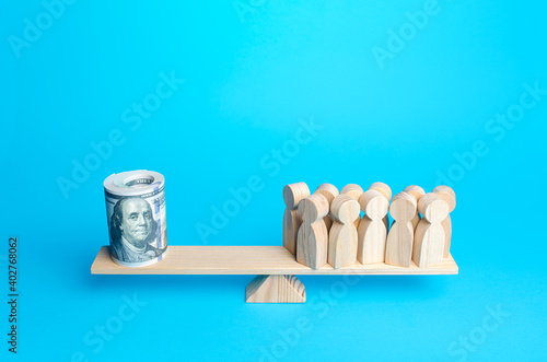Fotografie People and rolled up bundle of dollars on scales
