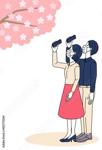 Man and woman taking pictures of cherry blossoms