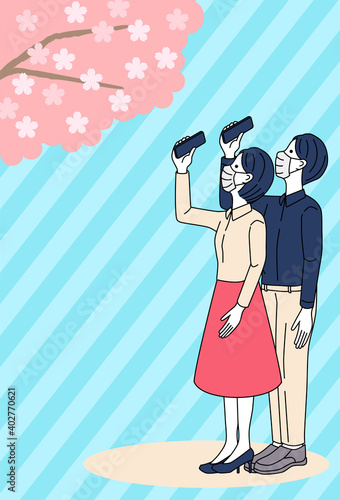 Man and woman taking pictures of cherry blossoms