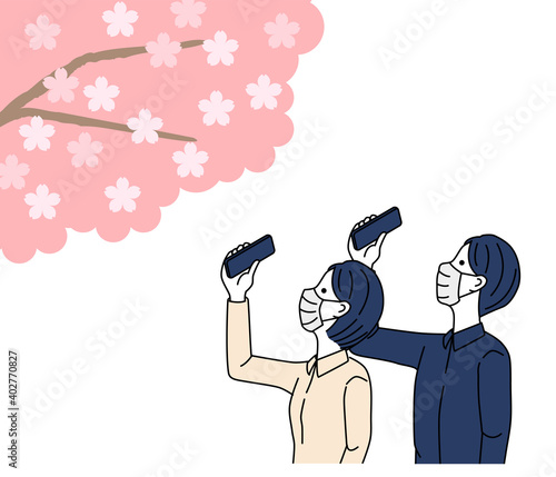 Man and woman taking pictures of cherry blossoms