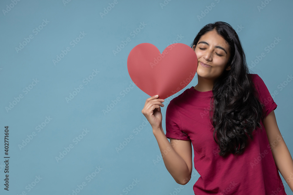 Mexican latin girl holding a red heart shaped paper valentine's day Mexican latin girl holding a red heart shaped paper valentine's day