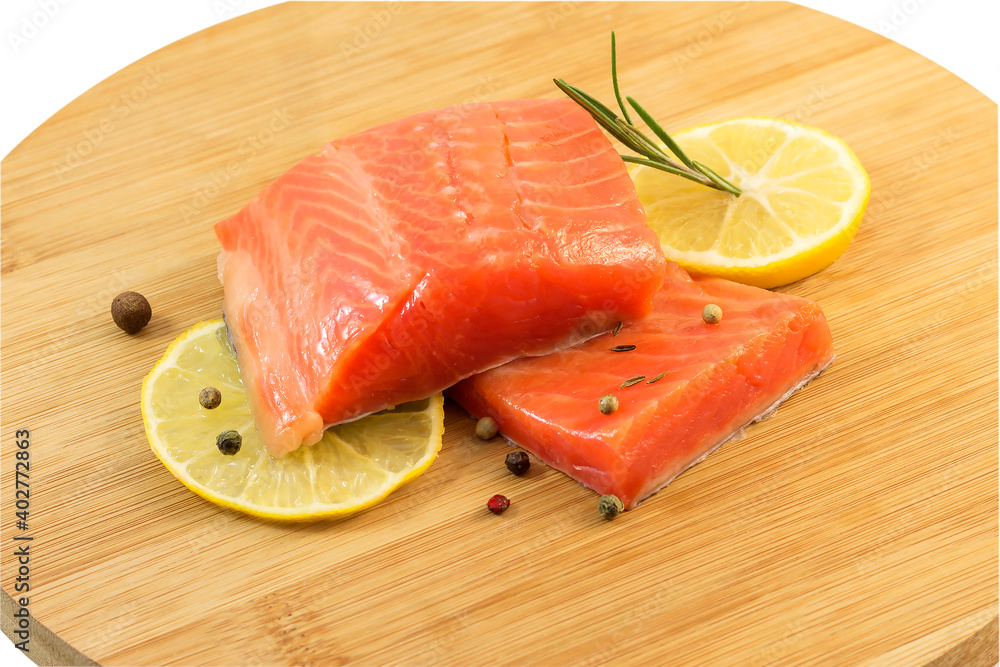 Pieces of red salted trout with lemon and spices on a cutting kitchen board. Pieces of red salted trout with lemon and spices on a cutting kitchen board.