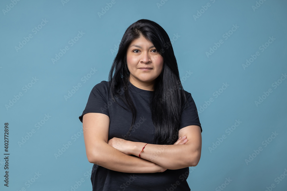 © Teran - Mexican latin woman arms crossed isolated blue background © Teran - Mexican latin woman arms crossed isolated blue background