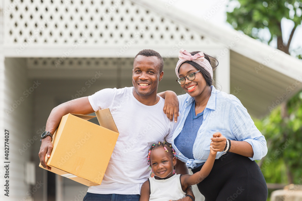 Cheerful african american family with luggage and carrying boxes into new home, Happiness family on moving day concepts Cheerful african american family with luggage and carrying boxes into new home, Happiness family on moving day concepts
