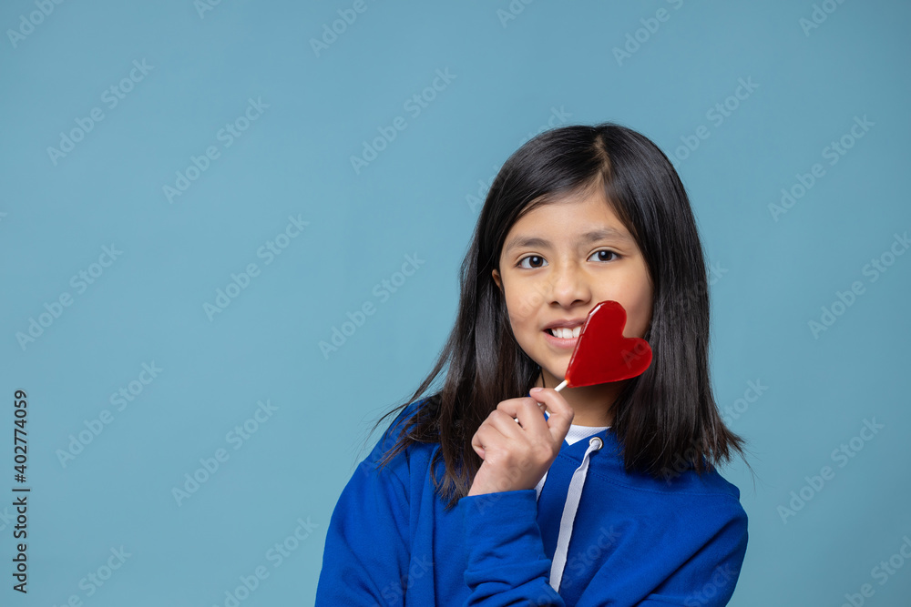 Mexican latin girl holding heart shaped lollipop self love concept Mexican latin girl holding heart shaped lollipop self love concept