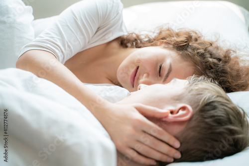 Young happy caucasian couple morning wake up lying together in bed