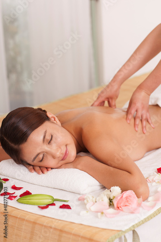 A young women lying in bed enjoying massage
