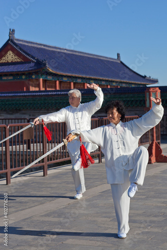 Two old people playing Tai Chi in the park