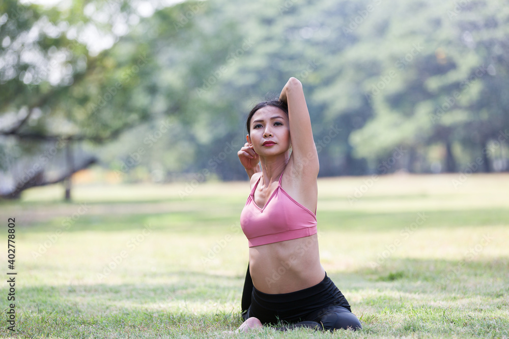 Asian woman doing yoga with stretching arms and leg outdoor in the park. Woman wearing sportswear and working out outdoor. Yoga and exercise outdoor concept Asian woman doing yoga with stretching arms and leg outdoor in the park. Woman wearing sportswear and working out outdoor. Yoga and exercise outdoor concept