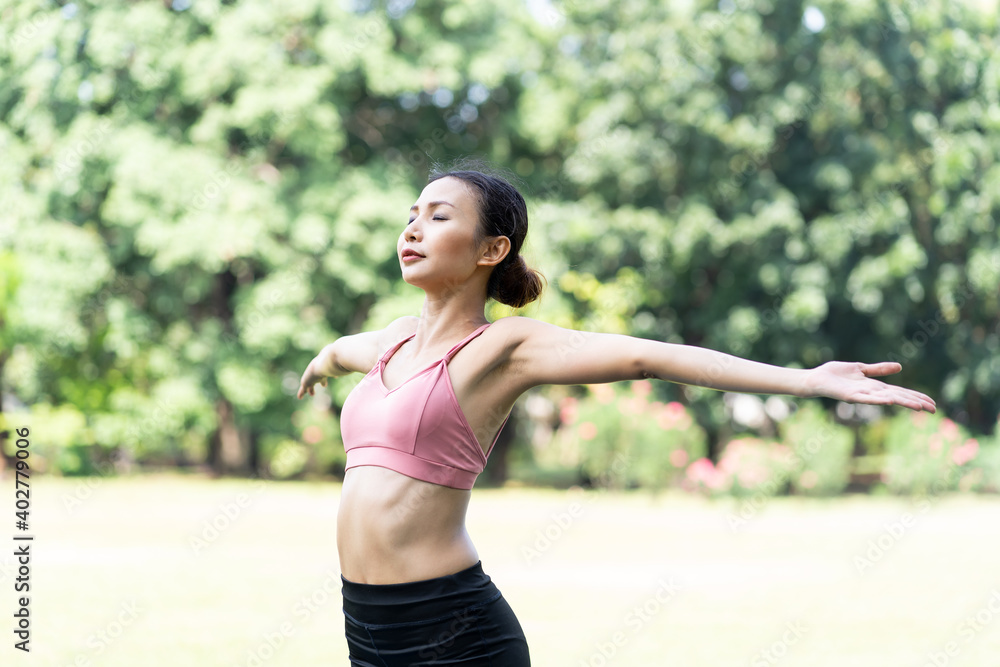 Asian woman practicing yoga outdoor in the park. Woman in sportswear doing yoga and stretching arms. Woman working out outdoor. Yoga and exercise outdoor concept Asian woman practicing yoga outdoor in the park. Woman in sportswear doing yoga and stretching arms. Woman working out outdoor. Yoga and exercise outdoor concept
