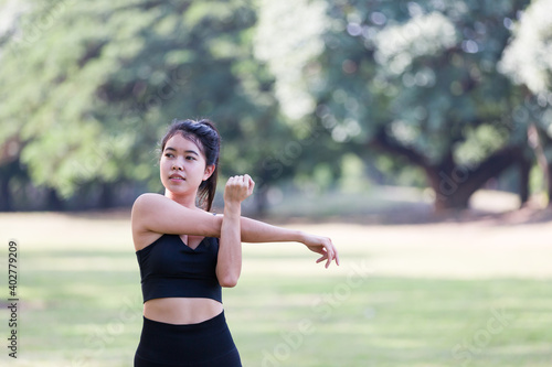 Attractive Asian young woman wearing sportswear doing stretching outdoor in the park. Sport woman warm up and exercise. Woman fitness outdoor. Working out, resting outdoor. People, Sport, healthy