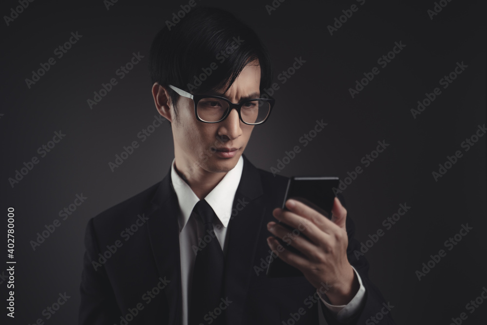 Businessman in black suit worried looking at smart phone. Businessman in black suit worried looking at smart phone.
