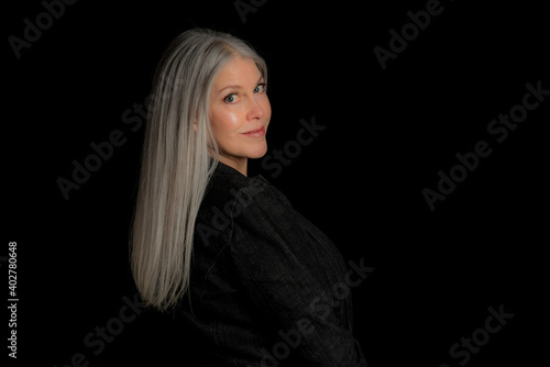 Image of a beautiful mature blond woman in the studio. Studio image with a black background.