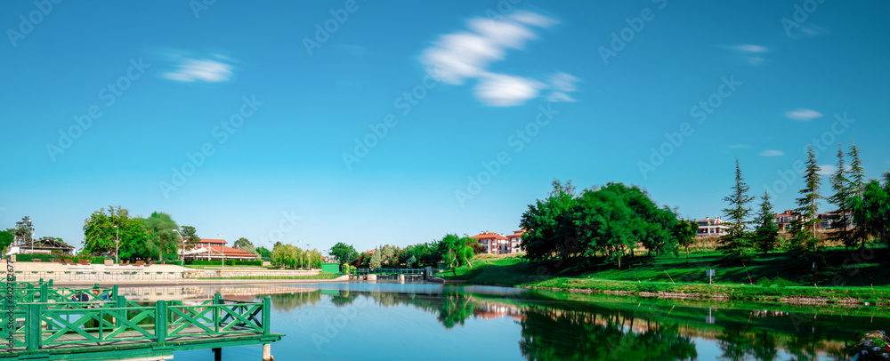 Scenic view natural park. Eskisehir, Turkey. The river flowing through the city. Reflections on the water. Long exposure. Panoramic shot. High resolution sharp photo. Panorama banner.