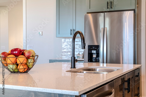 Fotografie Kitchen island with black curved faucet and stainless steel double bowl sink