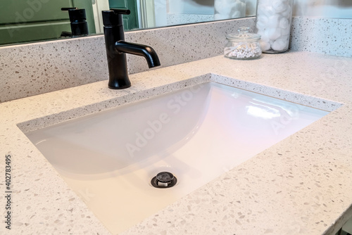 Tableau sur toile Black faucet over undermount white ceramic sink on the bathroom vanity of home