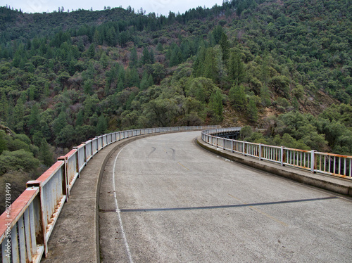 Curved bridge in forest with skid marks on road 