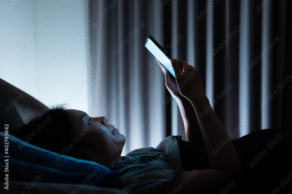 Asian woman on bed late at night and using mobile smartphone before sleep  Stock-Foto | Adobe Stock