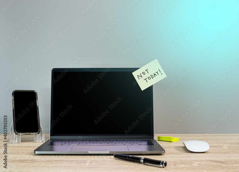 Not today on sticky note with turned off computer laptop and phone
