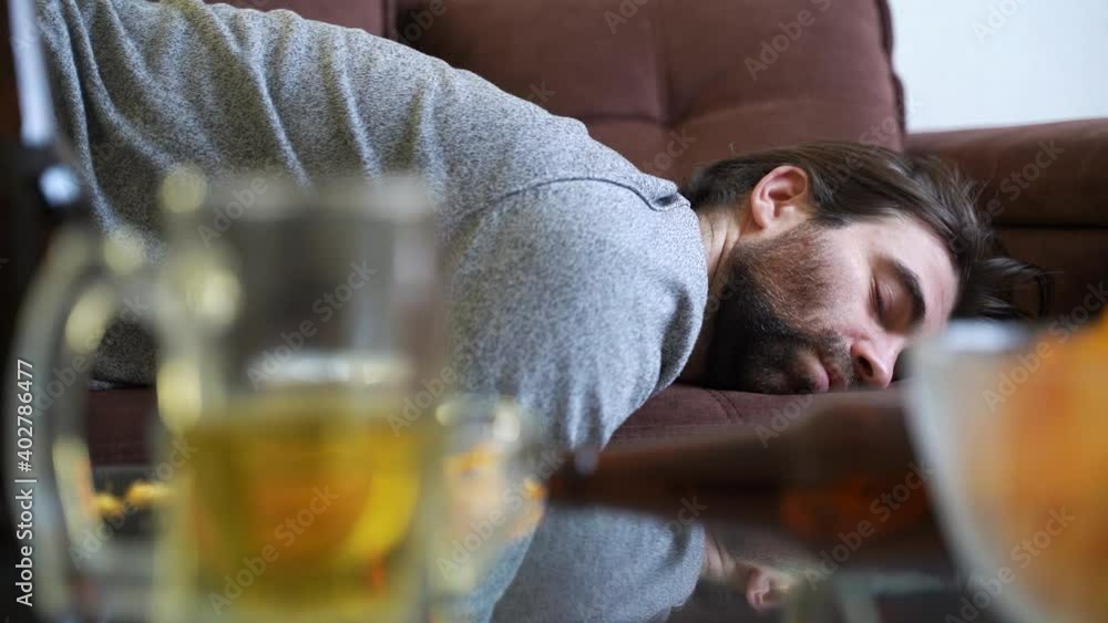 Video Stock Drunk man falling on sofa..Bearded male alcoholic falling ...