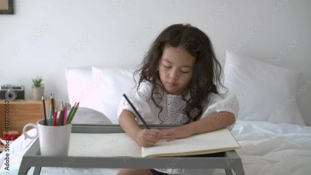 Asian young little girl drawing, painting on the empty paper. Asian young little girl drawing, painting on the empty paper.