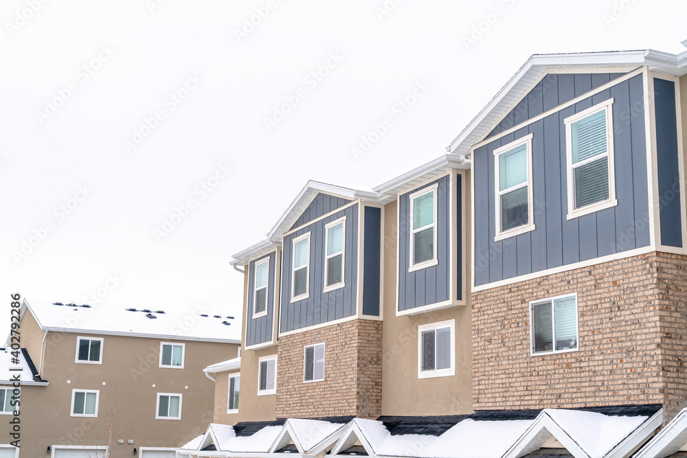 Upper floors of apartments and townhouses against snow and cloudy sky in winter