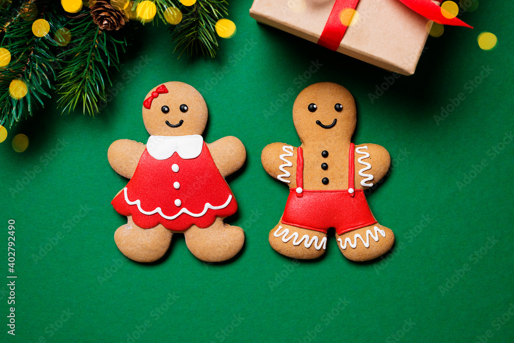 Naklejka premium Beautiful Christmas background with Gingerbread couple, Christmas trees and gift.Top view