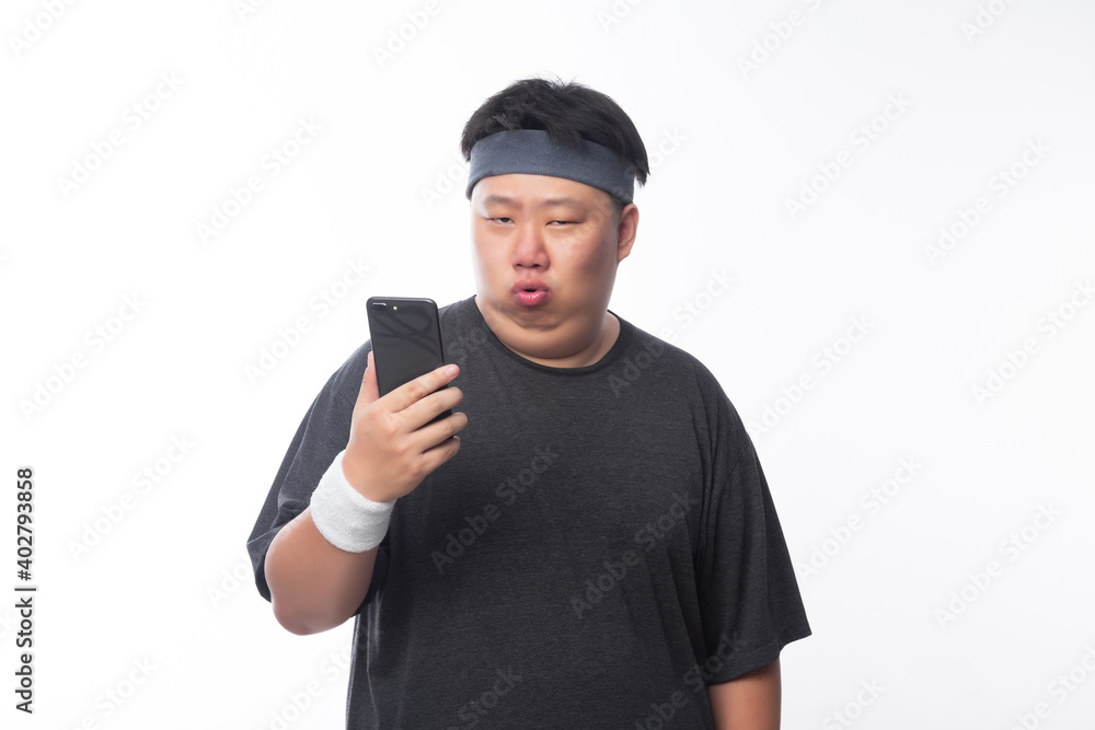 Young Asian funny fat sport man using smartphone isolated on white background. Young Asian funny fat sport man using smartphone isolated on white background.