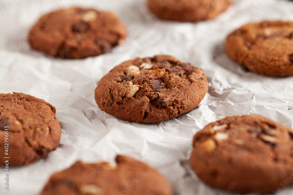 Fototapeta premium Chocolate cookies on white torn paper.