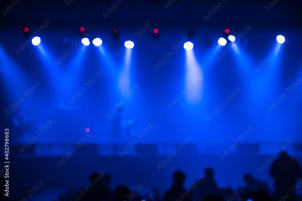 Abstract blurred photo of spotlight on the stage in conference hall or nightclub, silhouette audience or customer in restaurant,seminar and party environment,happy new year and merry christmas concept