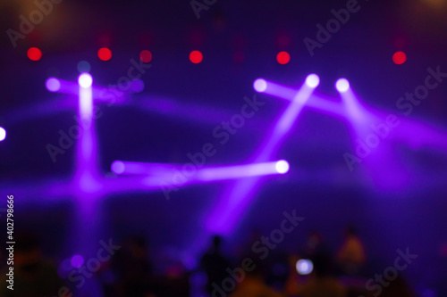 Abstract blurred photo of spotlight on the stage in conference hall or nightclub, silhouette audience or customer in restaurant,seminar and party environment,happy new year and merry christmas concept