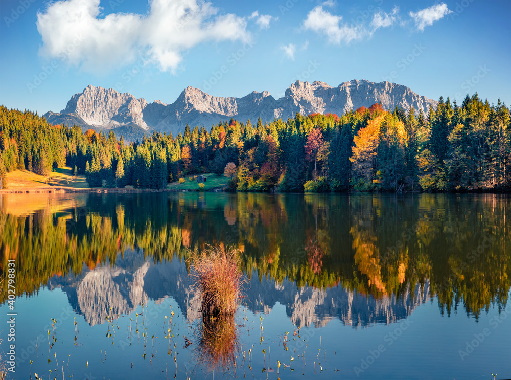 Fototapeta premium Beautiful autumn scenery. Nice evening view of Wagenbruchsee (Geroldsee) lake with Westliche Karwendelspitze mountain range on background. Autumn scene of Bavarian Alps, Germany.