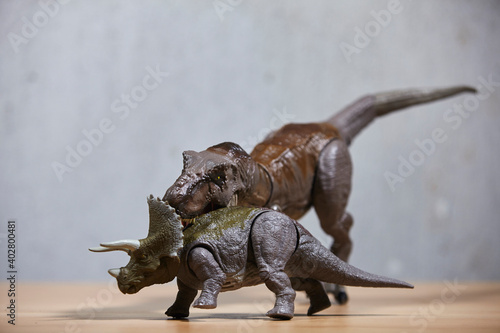 Dinosaur t-rex toys on wooden table.