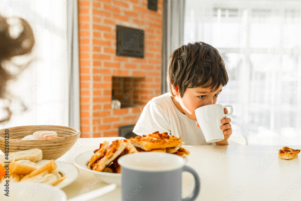 Preteen boy breakfast, portrait of smiling boy having breakfast at home