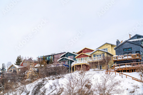 Family homes on a snowy mountain residential area against white sky in winter