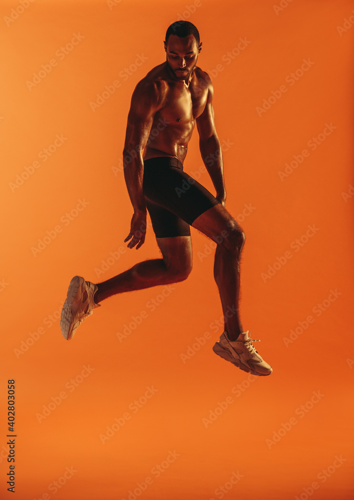 Muscular man jumping in air during workout