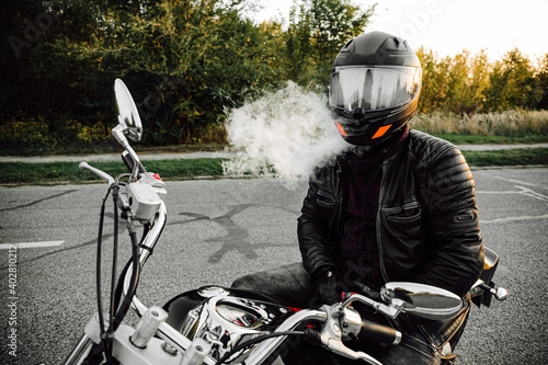 biker in a helmet sits on a motorcycle photo