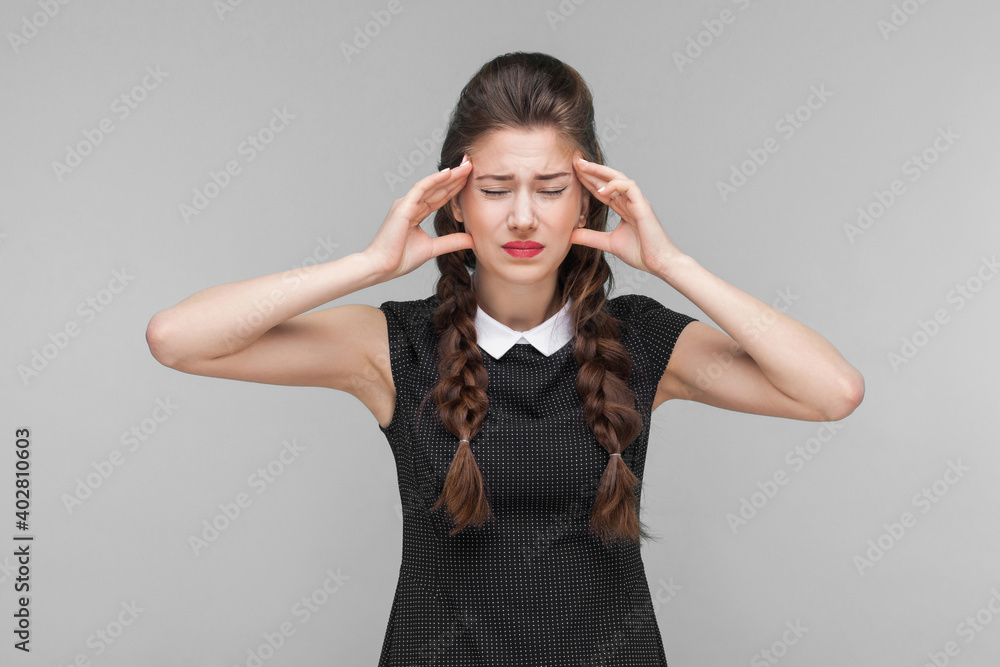 Young woman have migraine and headache. Indoor, studio shot isolated on gray background Young woman have migraine and headache. Indoor, studio shot isolated on gray background