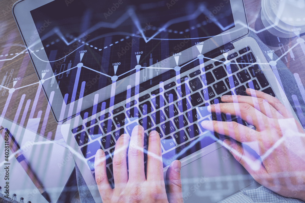 Double exposure of man's hands typing over computer keyboard and forex graph hologram drawing. Top view. Financial markets concept. Double exposure of man's hands typing over computer keyboard and forex graph hologram drawing. Top view. Financial markets concept.