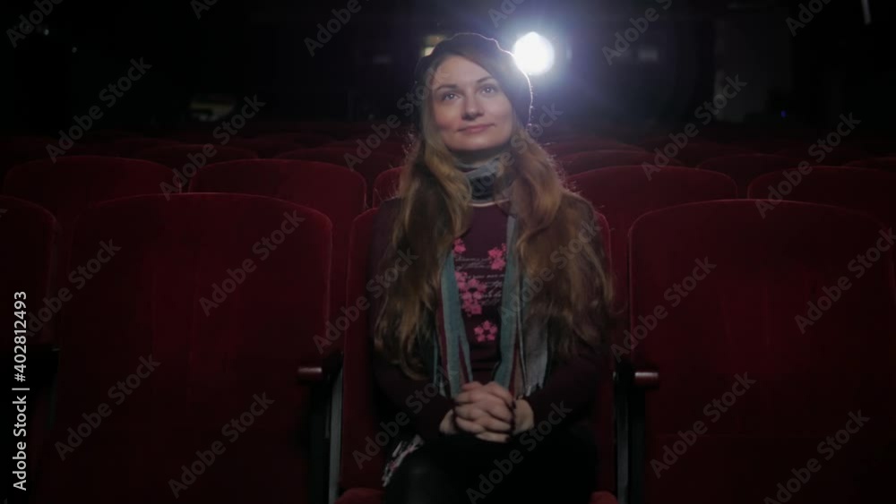 smiling young woman watching movie in the cinema smiling young woman watching movie in the cinema