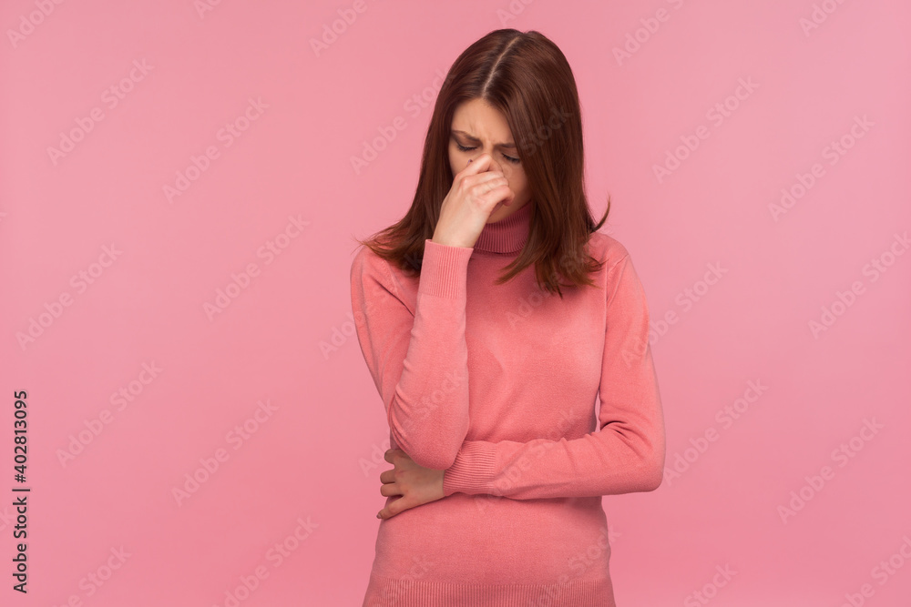 Nervous depressed brunette woman in pink sweater crying hiding eyes in hand, feeling desperated because of break-up or divorce. Indoor studio shot isolated on pink background Nervous depressed brunette woman in pink sweater crying hiding eyes in hand, feeling desperated because of break-up or divorce. Indoor studio shot isolated on pink background