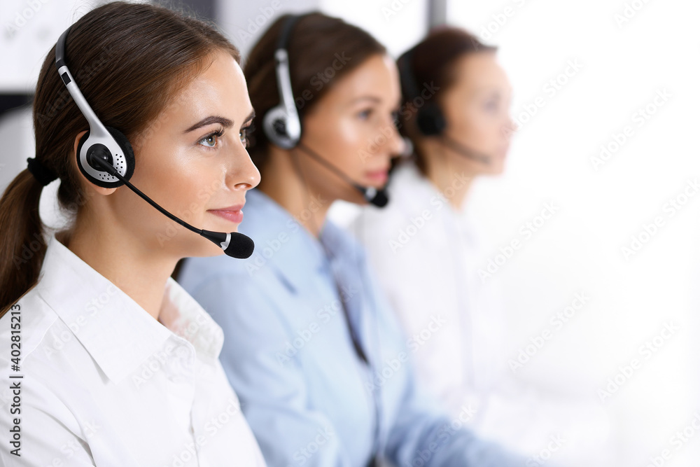 Call center. Group of operators at work. Focus on beautiful business woman in headset Call center. Group of operators at work. Focus on beautiful business woman in headset