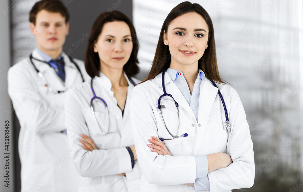 Group of young professional doctors is standing as a team with arms crossed in a hospital office and is ready to help patients. Medical help, insurance in health care, best disease treatment and Group of young professional doctors is standing as a team with arms crossed in a hospital office and is ready to help patients. Medical help, insurance in health care, best disease treatment and