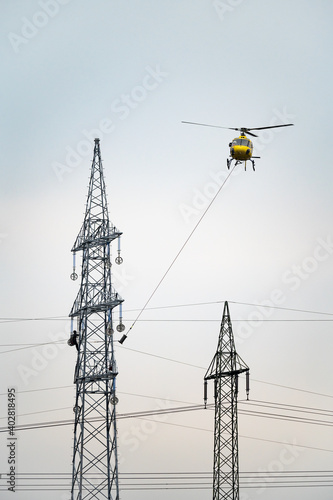 Leitungsinstallation am Strommast mit Helikopter